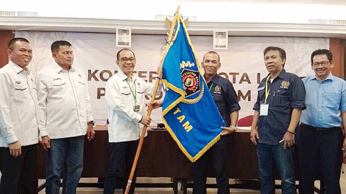 Ketua PWI Kepri, Andi Gino, menyerahkan bendera PWI kepada Ketua PWI Kota Batam, Agus Bagjana