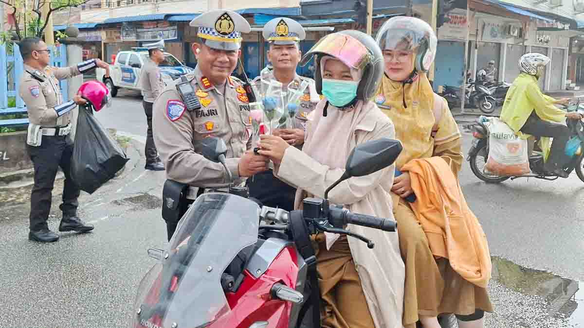 Satlantas Polres Kepulauan Meranti membagikan helm dan bunga kepada pengendara sepeda motor pada peringatan Hari Kartini tahun 2025
