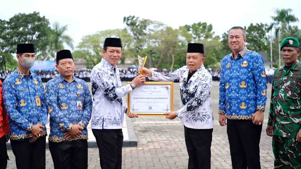 Bupati Kepulauan Meranti AKBP (Purn) Asmar memberikan penghargaan pada peringatan Hari Guru Nasional 2025